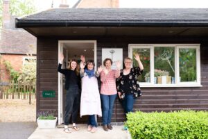 Picture of wistow gallery staff outside the entrance waving there hands saying hello.