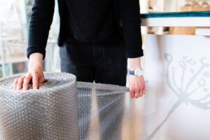Sarah gallery owner using sustainable bubble wrap.